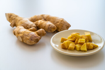 Ginger root and next to cut ginger on plate.
