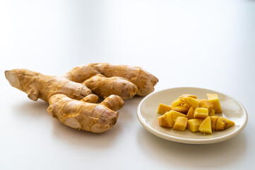 Ginger root and next to cut ginger on plate.
