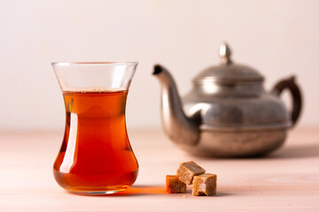 Black tea in armudu glass on wooden table