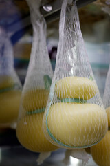 Delicious fresh Caciocavallo and Scamorza cheese hanging. Italian cheeses close up. The cheeses are...