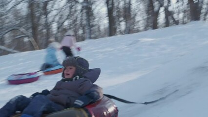 Smiling children playing with snow outdoors. Boy having fun in winter park with friends in vacation and holidays. Emotion, happiness, lifestyle concept. Snowboarder on the slope