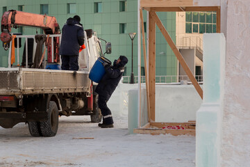 A worker unloads a barrel from a car body