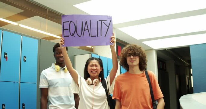 Multi-ethnic group of teenage students holding a sign with the slogan: equality