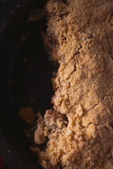Close up of delicious homemade apple crumble in low light. Dark food photo with copy space.