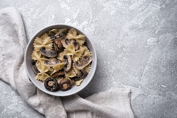 Bowl of italian farfalle pasta and mushrooms with cream sauce