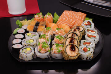 Japanese food combo of sushis and sahimis in black background