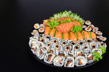 Japanese food combo of sushis and sahimis in black background