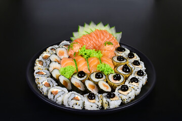 Japanese food combo of sushis and sahimis in black background