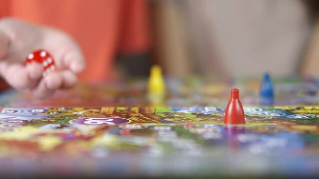 Chips for child game. Twi friends play with a chips and figure on the board game on the table.