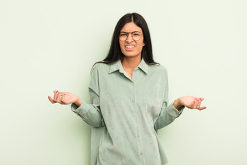 hispanic pretty woman feeling clueless and confused, not sure which choice or option to pick,...