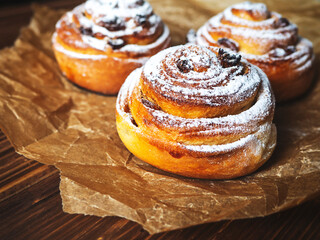 Buns with cinnamon and powdered sugar. The concept of cooking delicious food at home, homemade cakes.  Selective  focus.