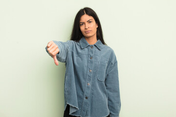 hispanic pretty woman feeling cross, angry, annoyed, disappointed or displeased, showing thumbs...
