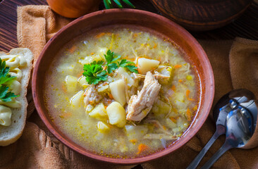 Buckwheat soup with meat in a clay bowl on the table.
