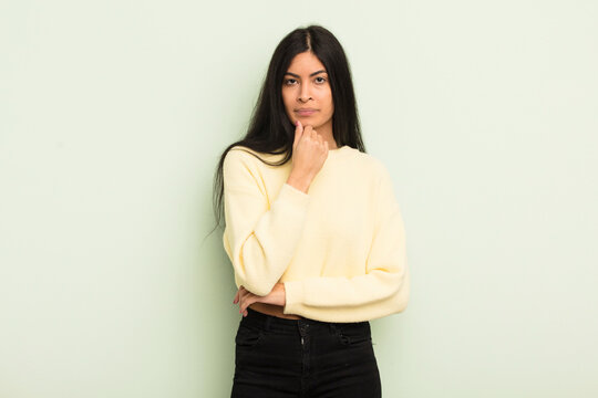 hispanic pretty woman looking serious, confused, uncertain and thoughtful, doubting among options or choices