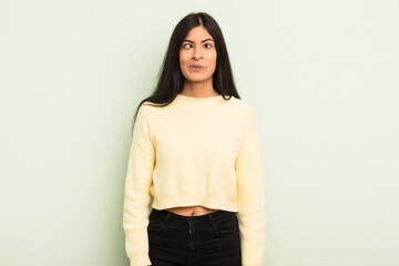 hispanic pretty woman looking goofy and funny with a silly cross-eyed expression, joking and...