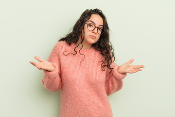 hispanic pretty woman feeling puzzled and confused, unsure about the correct answer or decision,...