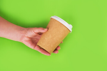 coffee cup of reusable materials in the hand on green background. zero waste concept. replacement for plastic cups