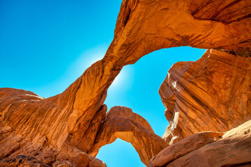 Double Arch ia a natural rock formation inside Arches National Park, Utah. Landscape under a blue sky