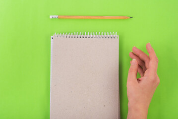 writting in the notebook with pencil on green background bussiness concept