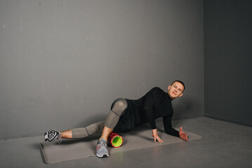 Athletic young man doing fitness with foam roller