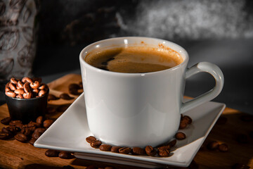 White cup and saucer of espresso coffee on a background of scattered coffee beans. Making coffee.