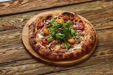 Pizza Caesar. Pizza with chicken, tomato, cheese and lettuce on wooden board. Top view. Free space for your text. Delivery food
