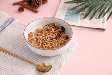 granola with milk with spoon isolated in pink background