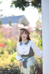 A beautiful woman in lolita dress in garden background Japanese street fashion portrait
