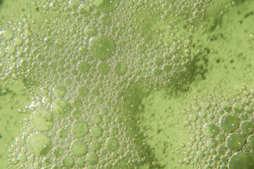 Cosmetic texture with bubbles on pastel green background. Cleanser, shampoo, wash - liquid soap, shower gel, hyaluronic acid, serum. Cosmetics banner