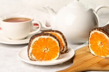 Sweet chocolate roll with tangerine filling and a cup of hot tea.