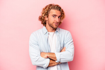 Young caucasian man isolated on pink background unhappy looking in camera with sarcastic expression.