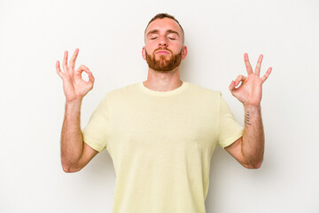 Naklejka premium Young caucasian man isolated on white background relaxes after hard working day, she is performing yoga.