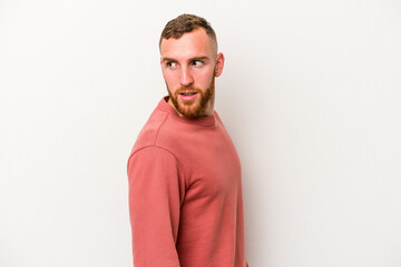 Fototapeta premium Young caucasian man isolated on white background looks aside smiling, cheerful and pleasant.