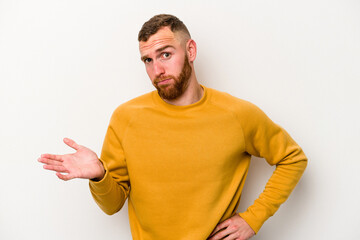 Young caucasian man isolated on white background doubting and shrugging shoulders in questioning...