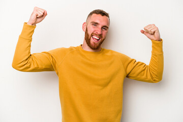 Young caucasian man isolated on white background cheering carefree and excited. Victory concept.