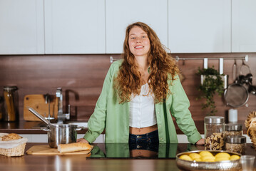 Close up portrait of a happy smiling woman on kitchen looking directly at the camera