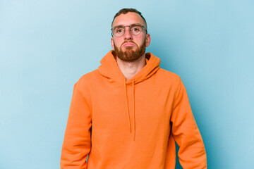 Young caucasian man isolated on blue background sad, serious face, feeling miserable and displeased.