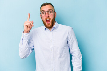 Young caucasian man isolated on blue background having an idea, inspiration concept.