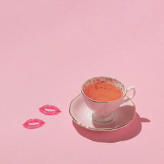 Vintage cup of tea and kiss lip prints on pastel pink background. 80s, 90s retro aesthetic romantic...