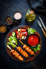 Chicken skewers - grilled meat with fresh vegetables on wooden background
