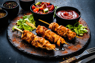Chicken skewers - grilled meat with fresh vegetables on wooden background
