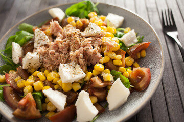 Plate of salad with tuna, corn, tomatoes and arugula