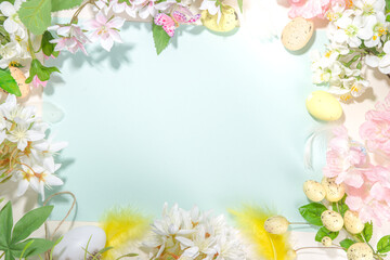 Naklejka na ściany i meble Easter holiday top view flat lay frame background with easter colorful eggs, and spring flowers. Spring holiday greeting card background, copy space