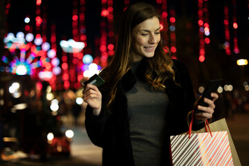 Beautiful woman holding shopping bags. Portrait of happy woman during Christmas shopping.