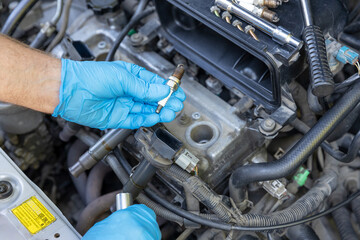 Car spark plug replacement. Repairing of vehicle. - obrazy, fototapety, plakaty