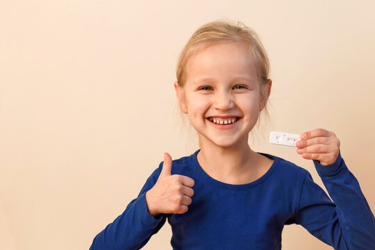 Сoronavirus Test In Children. Negative Result Of Covid-19 Testing In Happy Child Hands. Little Girl Shows Swab Rapid Self Test Of Covid. World Health Day