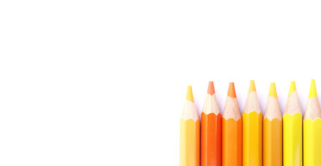 Colored pencils lined up on white paper background. Copy space. Back to school. Office supplies.