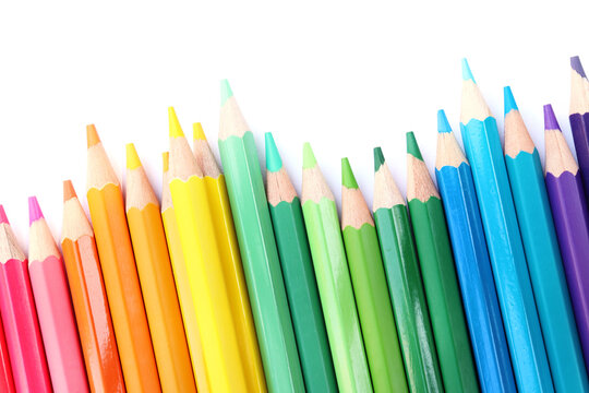 Colored pencils lined up on white paper background. Copy space. Back to school. Office supplies.