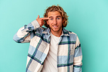 Young caucasian man isolated on blue background showing a disappointment gesture with forefinger.