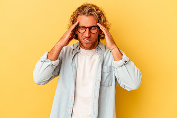 Young caucasian man isolated on yellow background touching temples and having headache.